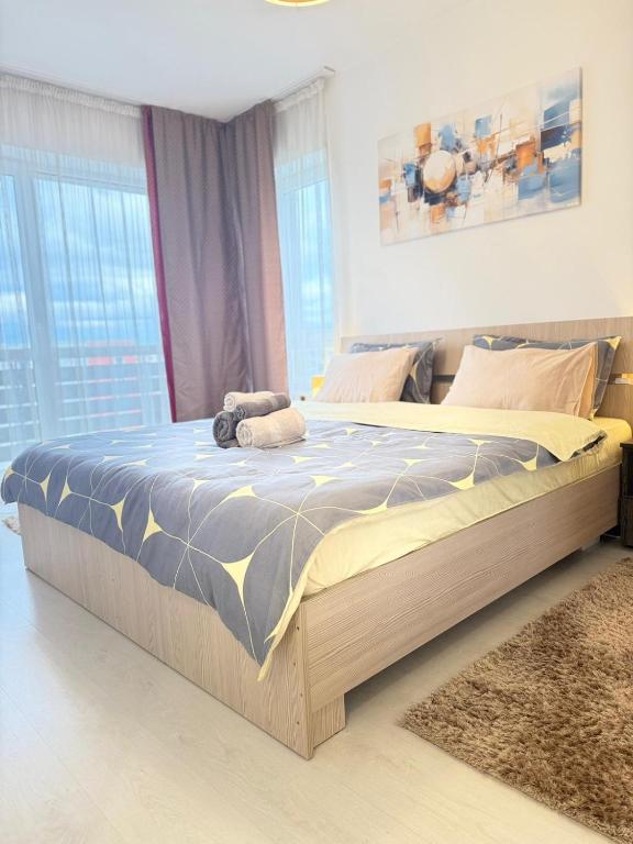 a bedroom with a large bed in a room with windows at Casa MIO in Braşov