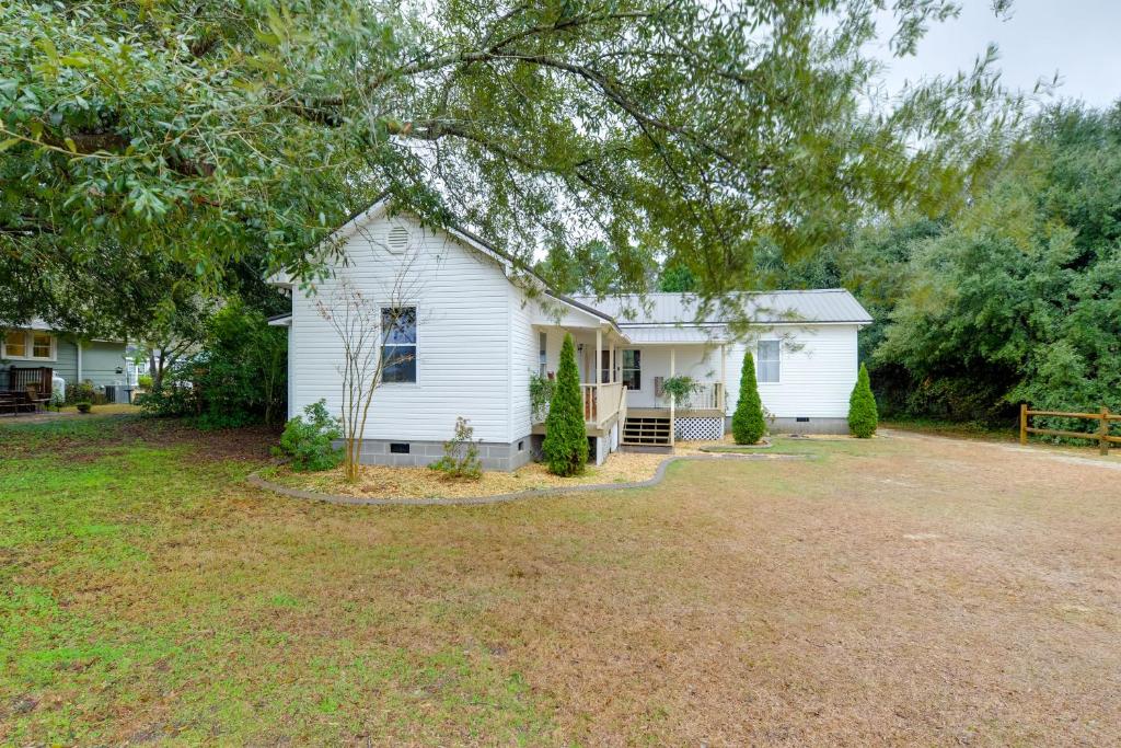 Sweet Southern Pines Abode with Yard and Covered Porch في سوثيرن باينس: بيت ابيض وامامه ساحه