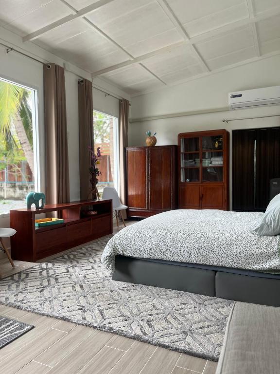 a bedroom with a large bed and a large window at Phimai Pond House in Phimai