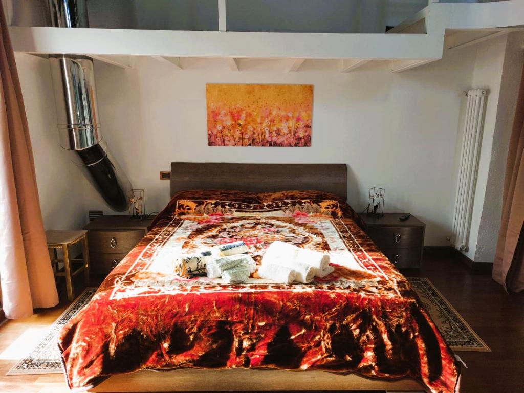 Casa nonna Gina في سان فرانشيسكو أل كامبو: غرفة نوم بها سرير وبطانية حمراء