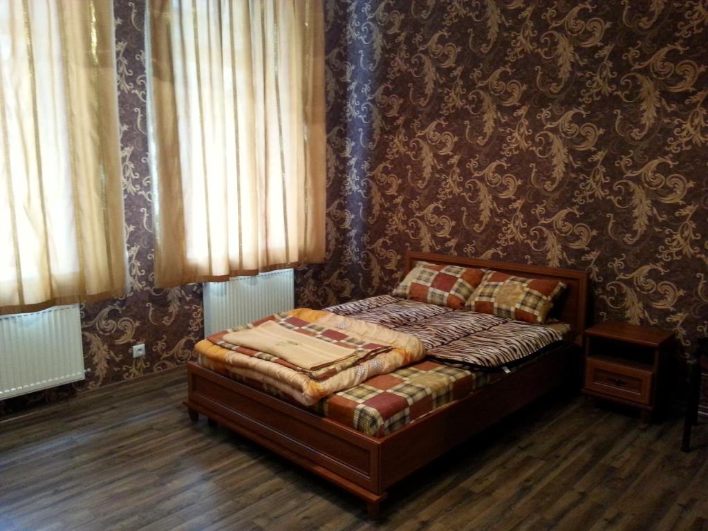 ヴィーンヌィツャにあるApartments in Centerの壁のある部屋のベッド1台が備わるベッドルーム1室を利用します。