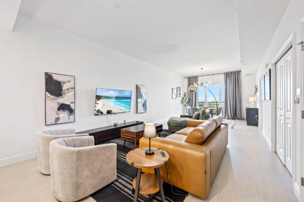 RIVER FLY-IN Luxury Condo w Views & Amenities RFI-1003 في Audubon: غرفة معيشة مع أريكة وكراسي