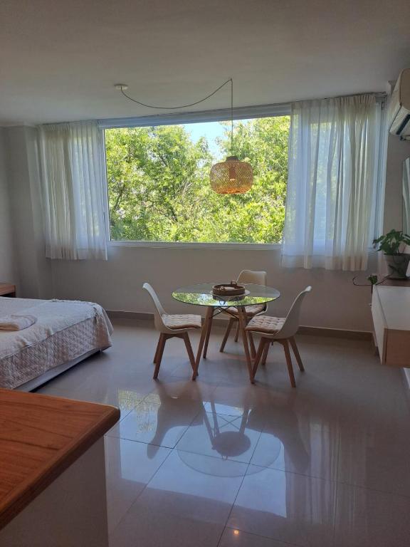 a bedroom with a table and chairs and a bed at Agora Neo in Pinamar