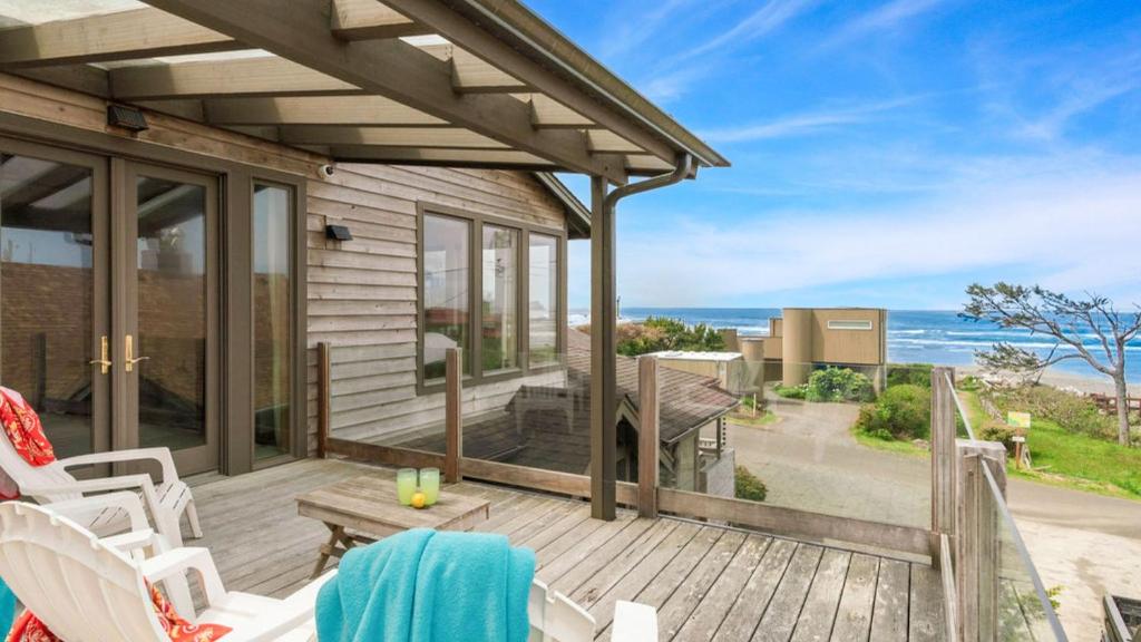 a house with a deck with a view of the ocean at The Castle Rock Estate by AvantStay Steps From Arch Cape beach w Hot Tub Sauna in Arch Cape
