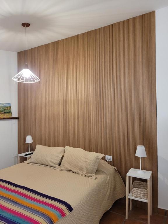 una camera da letto con un letto con una parete in legno di LO DE MECHI a Salta