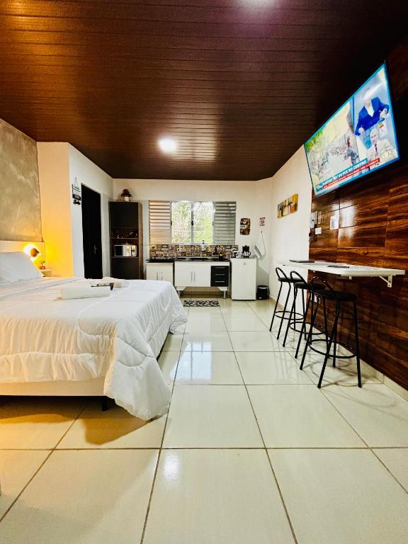 a bedroom with a bed and a flat screen tv at Hospedagem Marechal 02 in São Roque