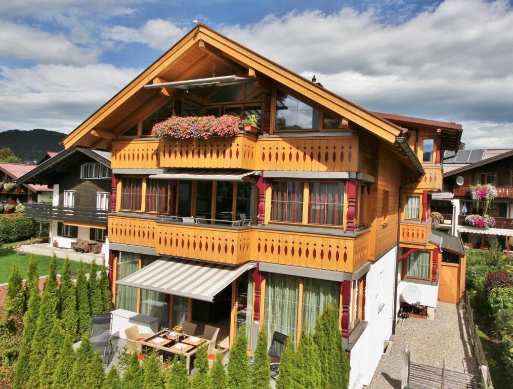 uma casa com uma varanda com flores em Landhaus Alpenflair Whg 310 em Oberstdorf