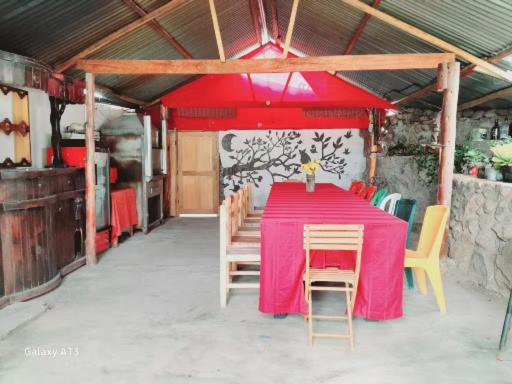 a table with a pink table cloth and chairs at Casa Corazao in Urubamba