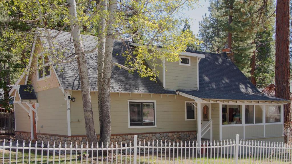 a small yellow house with a white fence at Aster by AvantStay Classic Kings Beach Cottage In The Of North Shore in Kings Beach