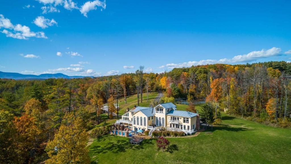an aerial view of a large house in the woods at River House by AvantStay Historic Secluded Estate on the Hudson River w Pool Sleeps 24 in Hudson