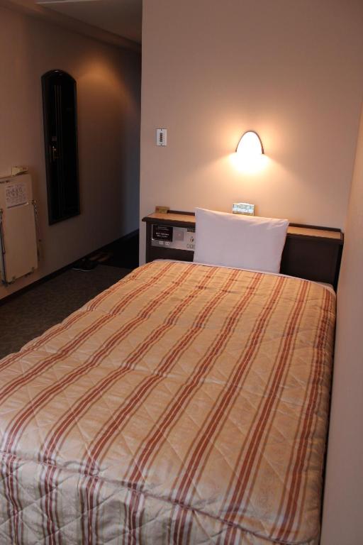 Postel nebo postele na pokoji v ubytování Hotel Crown Hills Takaoka