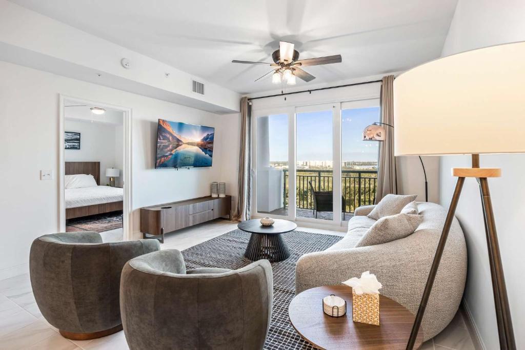 Luxury Condo Retreat in Merritt Island RFI-1004 في Audubon: غرفة معيشة مع أريكة وكراسي ونافذة