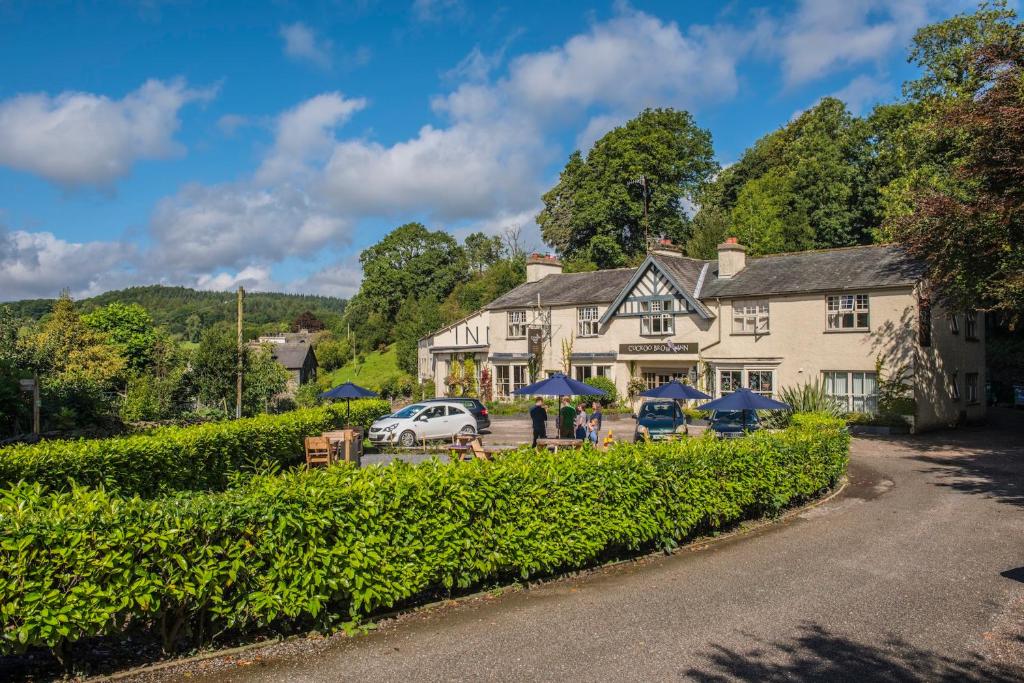 a large white building with blue umbrellas in front of it at The Cuckoo Brow Inn in Far Sawrey