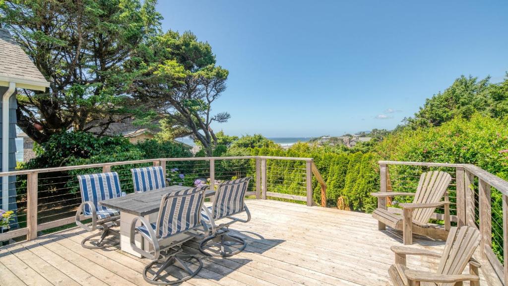 a wooden deck with three chairs and a table at Beach Pines Bungalow by AvantStay Classic Cottage Steps to the Beach w Private Yard in Arch Cape