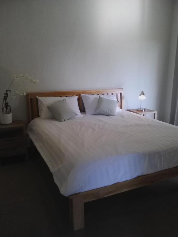 a bedroom with a large bed with white sheets and pillows at Ju'Blu Hotel in Lovina