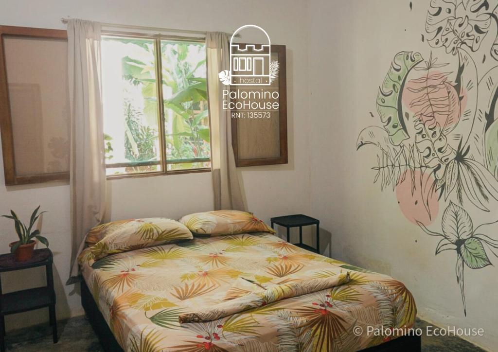 帕洛米诺Hostal Palomino EcoHouse & Camping的一间卧室，墙上有一张床和一块牌子