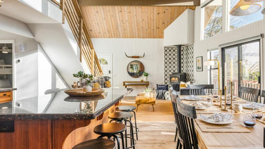 a kitchen and living room with a long bar with stools at North Bay by AvantStay Chic Retreat w Peloton in Blue Jay