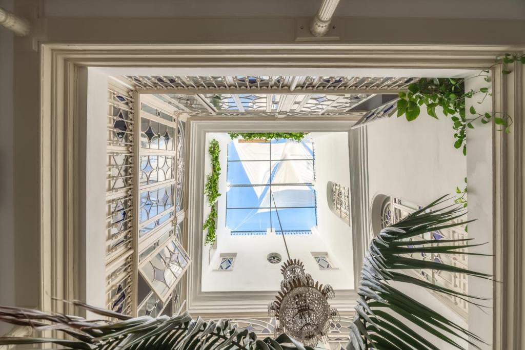 - un miroir dans une chambre avec fenêtre dans l'établissement Hotel Boutique Casa de Colón, à Séville