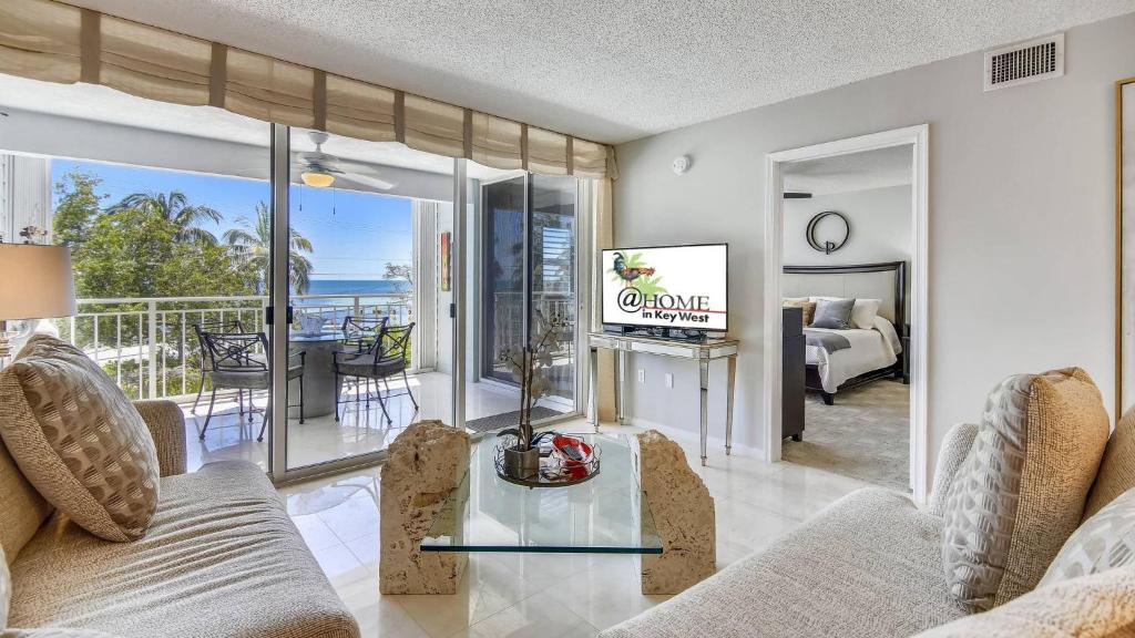 a living room with a couch and a glass table at Dune Wind South by AvantStay Communal Pool Hot Tub Gated Community Close to Smathers Beach Month Long Stays Only in Key West
