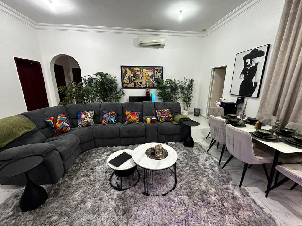 a living room with a couch and a table at Stylish 2 Bedroom with 2 outside area in Abu Dhabi