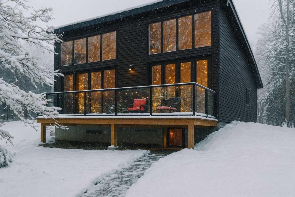 una casa nella neve con due sedie rosse di 3-bedroom Lakefront Villa #9 a Lakefield