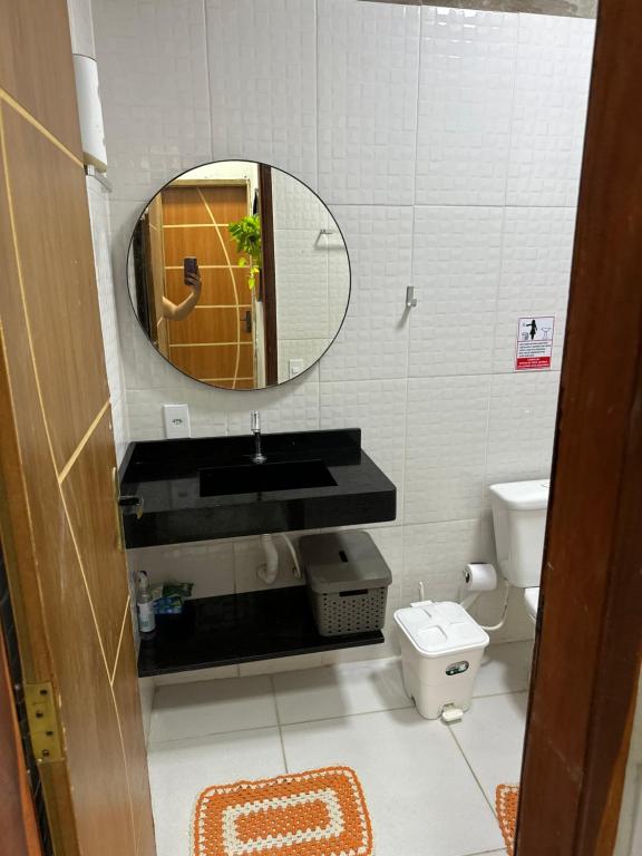 een badkamer met een wastafel en een spiegel en een toilet bij Brisa das dunas in Tutóia