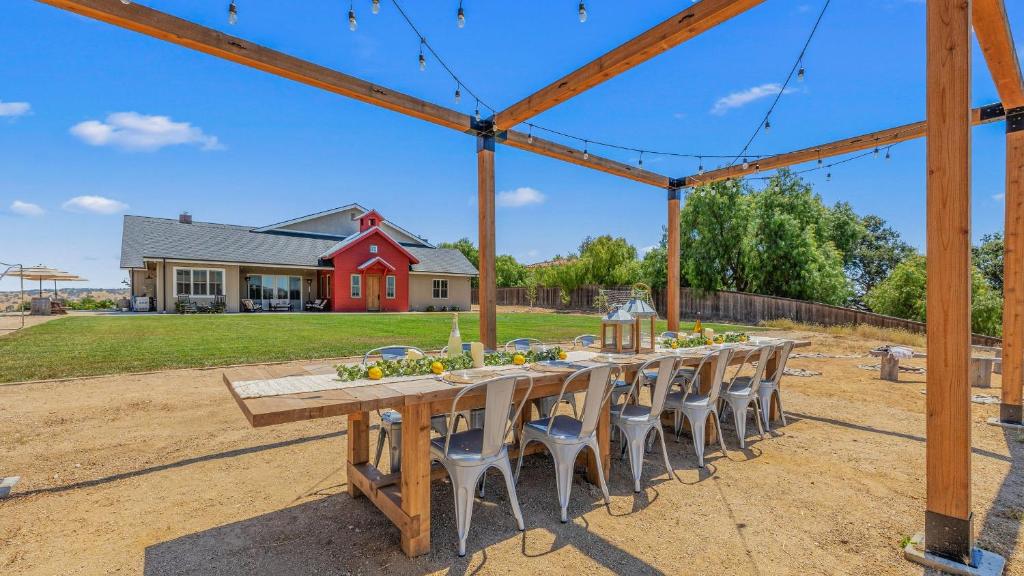 a long wooden table and chairs in a yard at Cooperage by AvantStay Vineyard Views Soccer in Templeton
