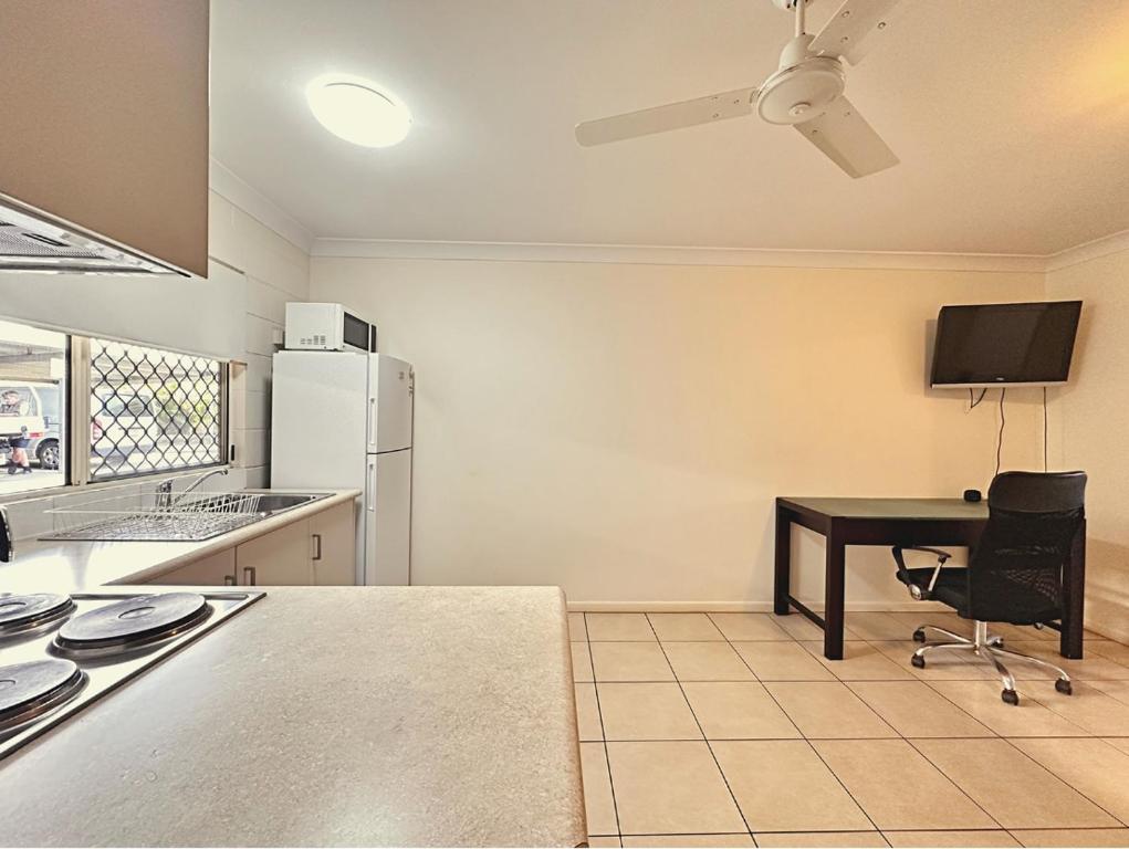 an empty kitchen with a table and a refrigerator at Unit 3 37 St Francis Dr Neat 1BR - AC & Parking in Moranbah