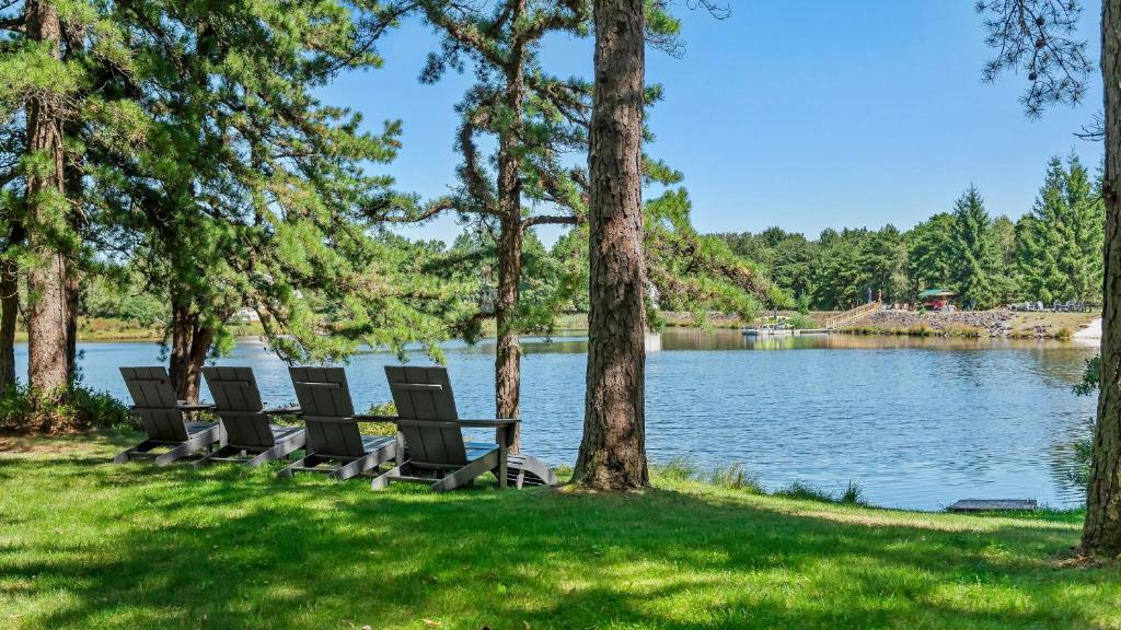 Lake It Right by AvantStay Lakefront w Dock Hot Tub Fire Pit Game Room في Long Pond: يوجد كرسيان على العشب بالقرب من البحيرة
