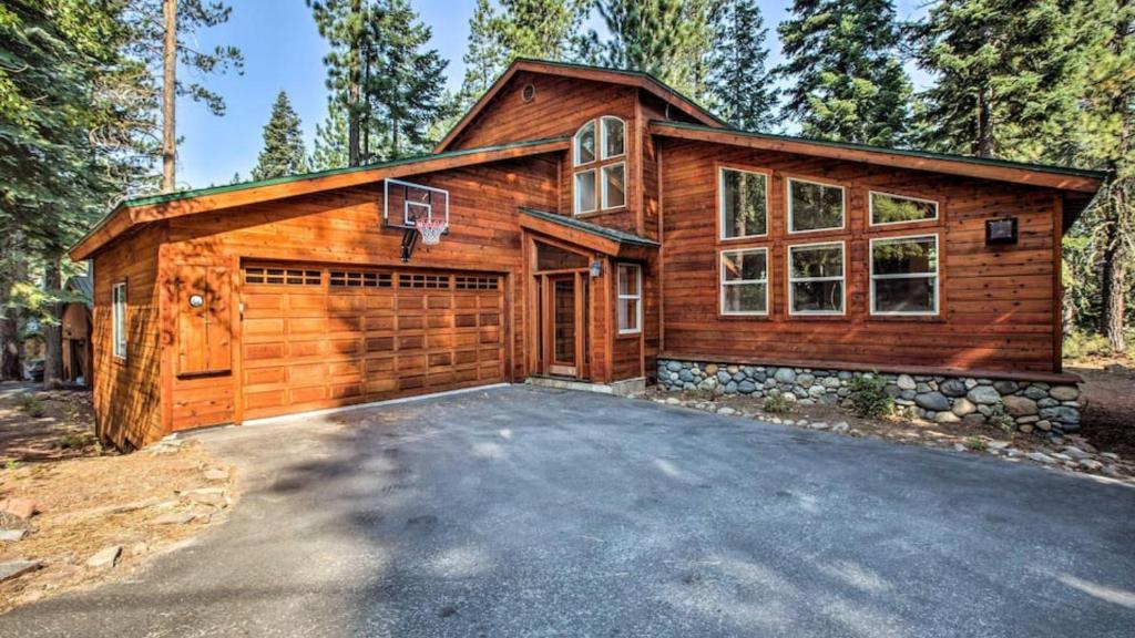 a log home with a garage and a driveway at Moosetrack by AvantStay Cozy Cabin w Hot Tub In The Heart of Tahoe Donner in Truckee