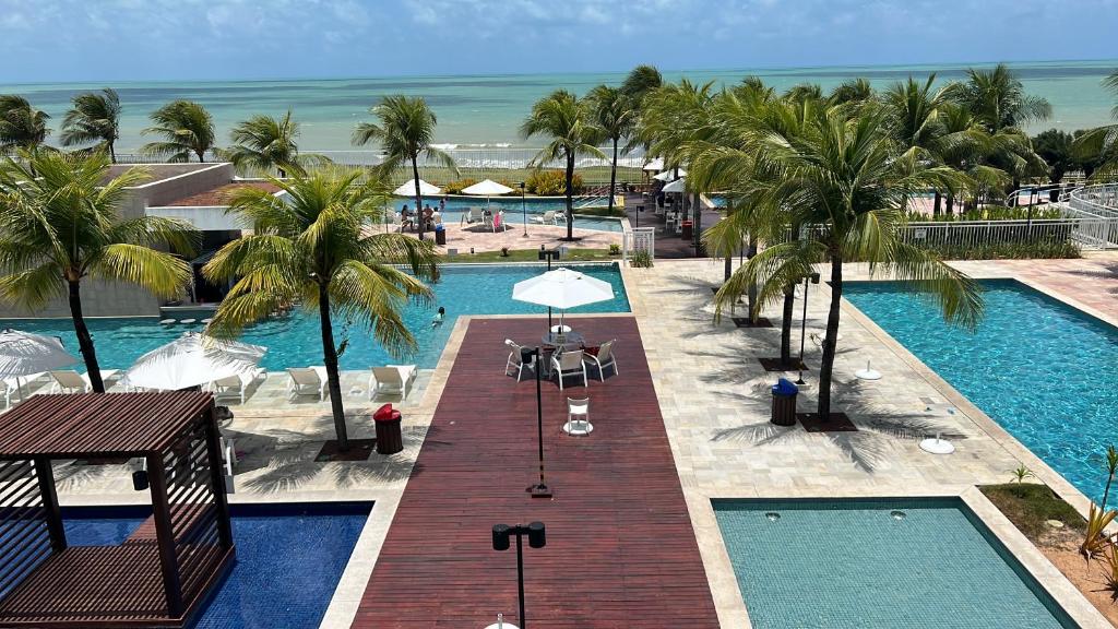 an overhead view of a pool with palm trees and the ocean at In mare Bali Resort in Parnamirim