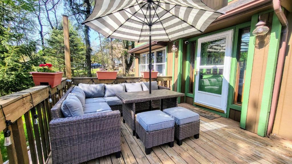 The Wooden Nest by AvantStay Deck Big Yard w Hammocks Fire Pit في Long Pond: فناء مع طاولة وكراسي ومظلة