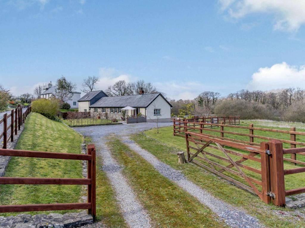 a fence next to a field with a house at 2 Bed in Clynderwen 82445 in Clynderwen