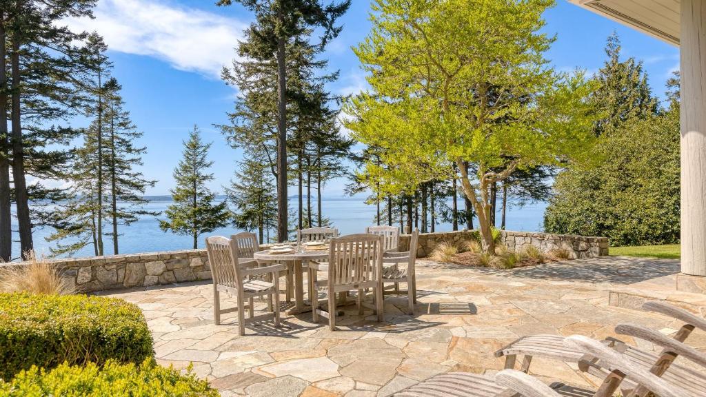 a patio with a table and chairs and the water at Goldilocks by AvantStay Luxury Waterfront Home in Greenbank