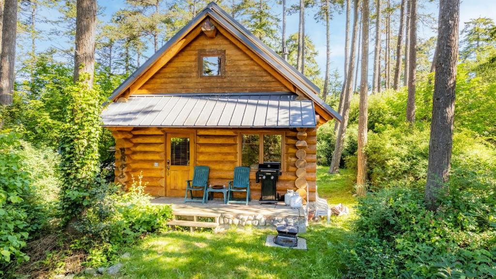 Penn Cove Overlook by AvantStay Cabin w Views في أوك هاربور: كابينة في الغابة مع طاولة وكراسي