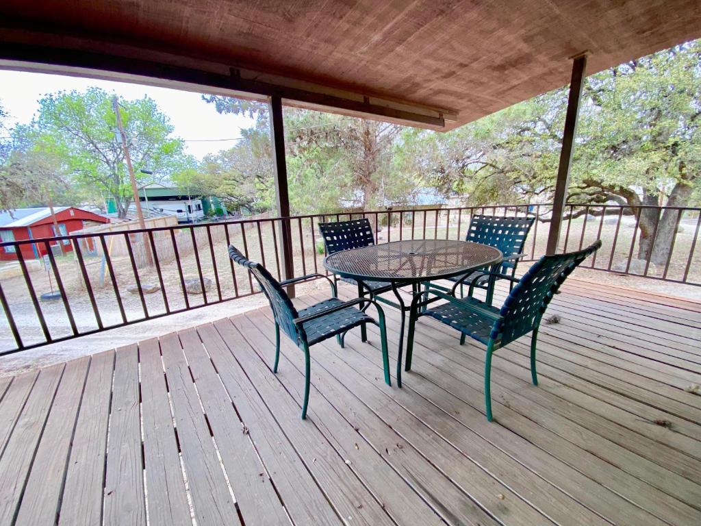 a table and four chairs on a deck at Shady Oak in Concan