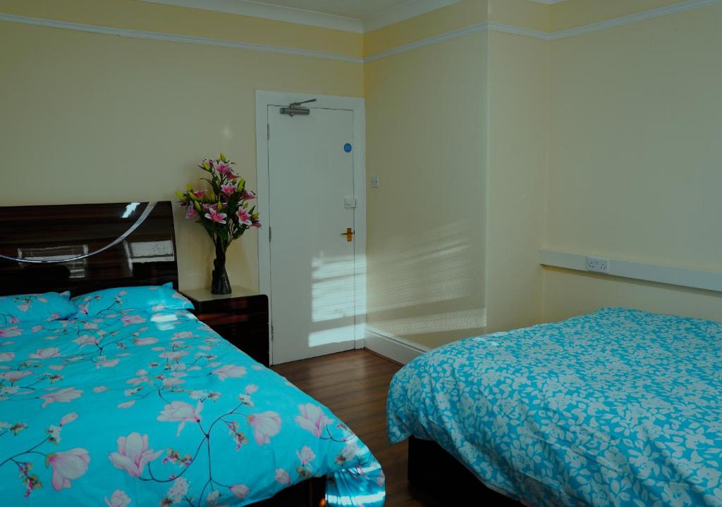 a bedroom with a bed and a vase of flowers at SS Sunrise & Silk in Bersted