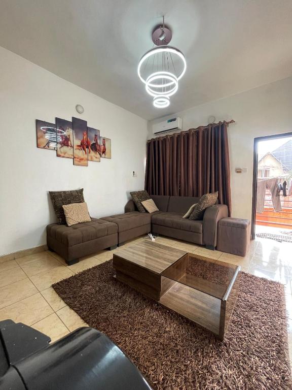 a living room with a couch and a coffee table at Modern 1 Bedroom Apartment with Balcony in Enugu