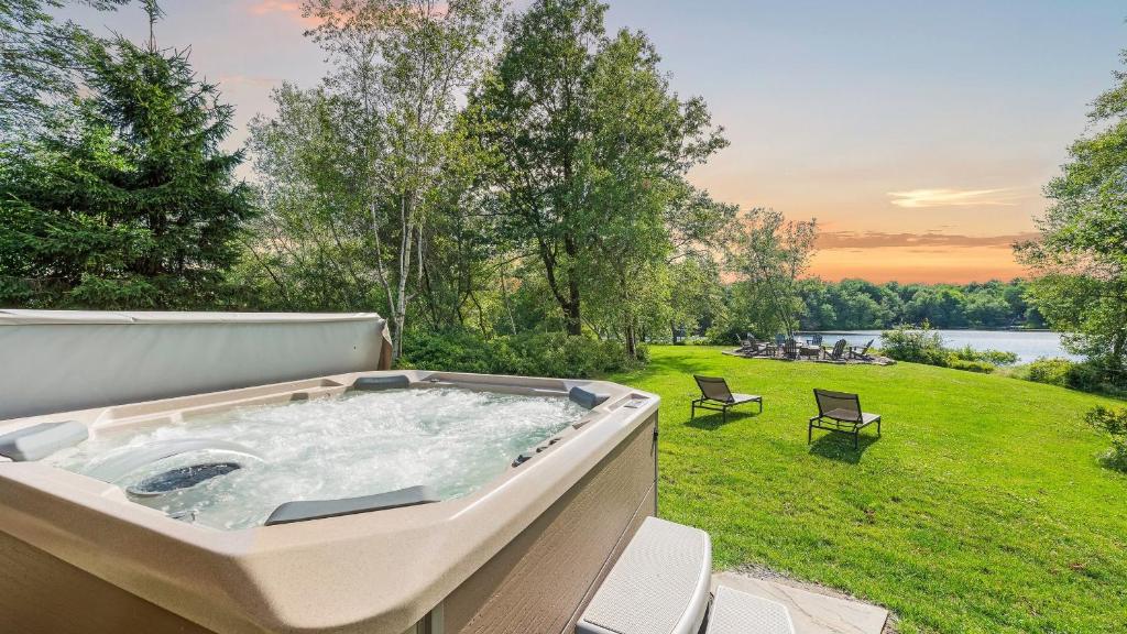 Waterside Haven by AvantStay Lakefront Hot Tub Game Room Fire Pit في Long Pond: وجود حوض استحمام ساخن فوق الفناء