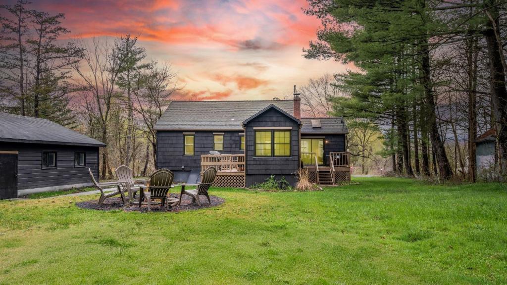 a house with a table and chairs in a yard at Charcoal Chalet by AvantStay A Design w Firepit in New Paltz