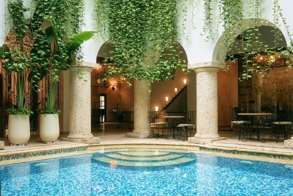 a swimming pool in a building with plants at Hotel Boutique Patio Corao in Cartagena de Indias