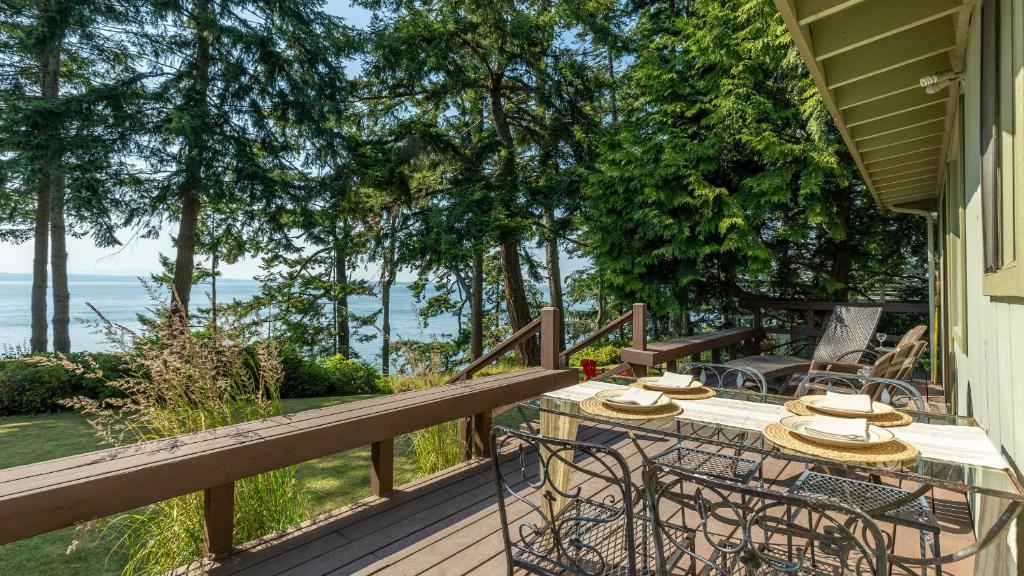 a wooden deck with a table and chairs on it at Mutiny Bay Waterfront Cabin by AvantStay Views in Freeland