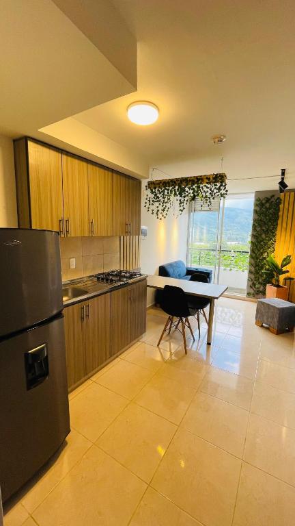 a kitchen with a refrigerator and a table in it at Refugio de la cordillera in Armenia
