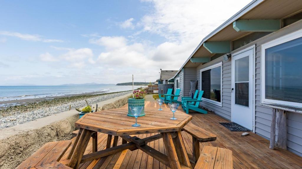 a picnic table on the deck of a beach house at West Beach Wonderland by AvantStay Waterfront in Oak Harbor