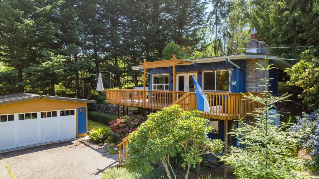 a house with a deck and a garage at Mid-Century Beach Cabin by AvantStay Walk to Beach in Coupeville