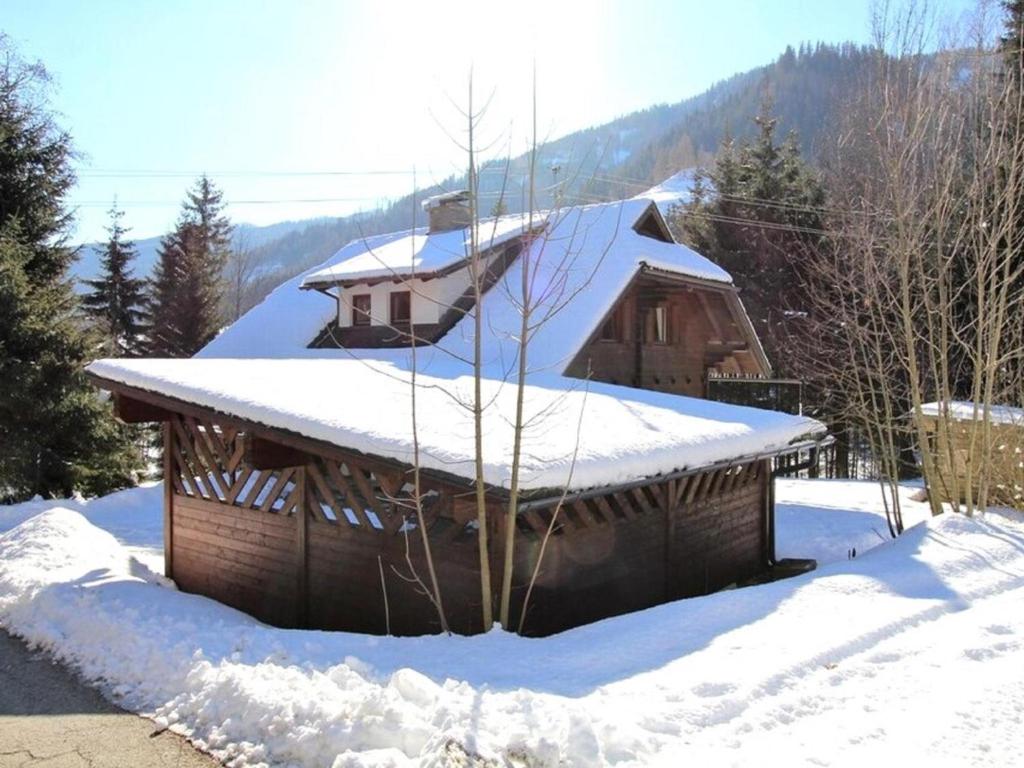 a log cabin with snow on the roof at Mooshausl in Gnesau