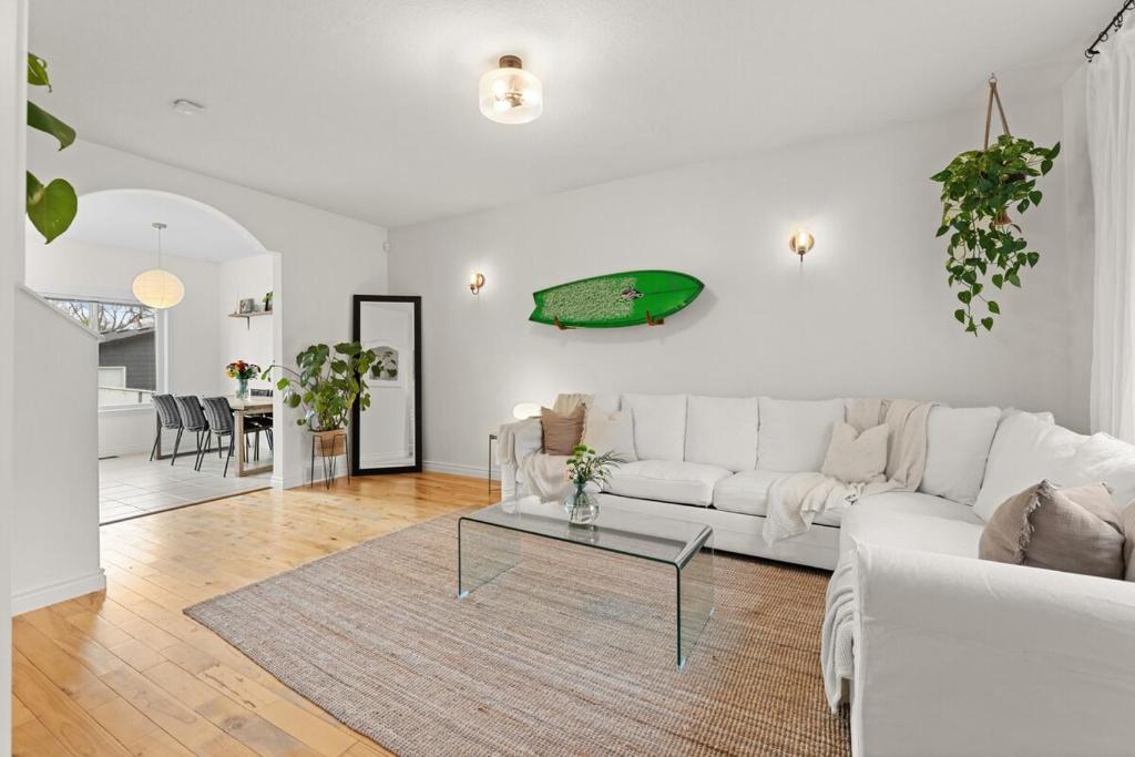 a living room with a white couch and a table at Stylish 3-Bedroom Home in Buena Vista in Saskatoon