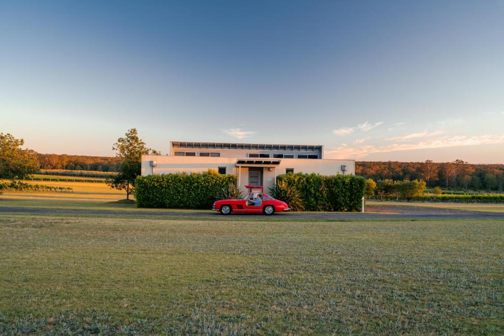 Un coche rojo aparcado delante de un edificio en Adina Vineyard, en Lovedale