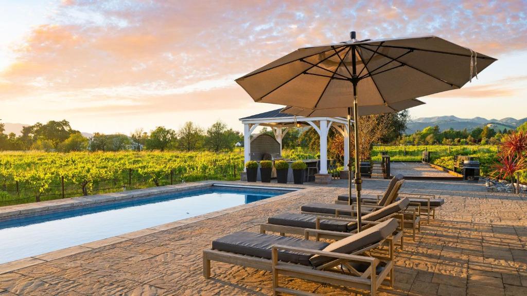 a swimming pool with lounge chairs and an umbrella at Chic Sonoma Oasis w Pool Bocce Hot Tub Minutes to Downtown in Sonoma