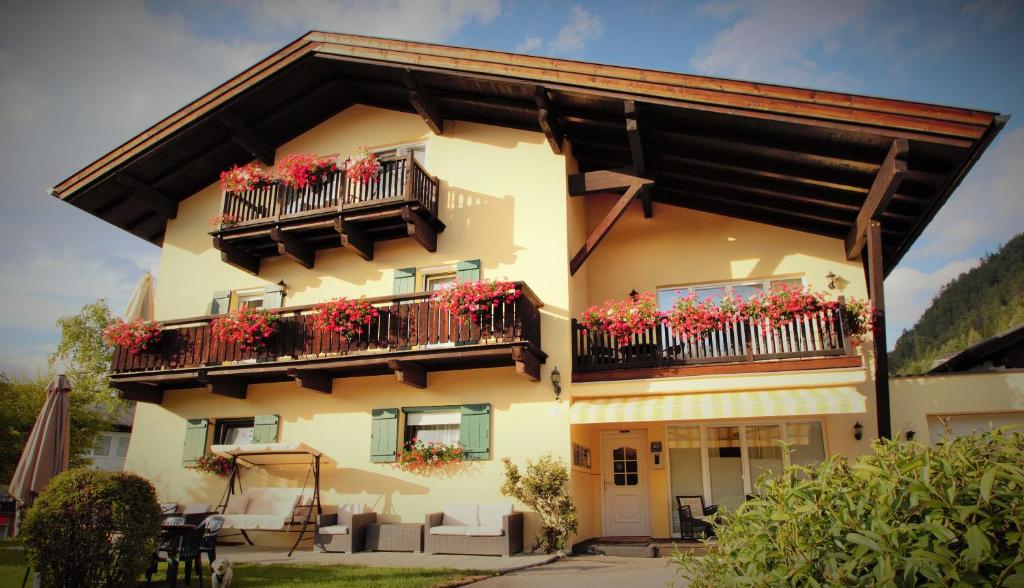 ein Gebäude mit Blumenkästen auf den Balkonen in der Unterkunft Alpenlandhaus Menardi in Seefeld in Tirol